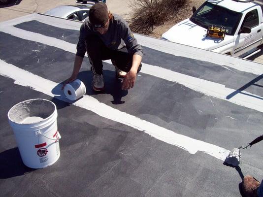 Emmbedding Conklin's Spun Flex II fabric into Conklin's Rapid Roof III base coat on all the seams and penetrations.