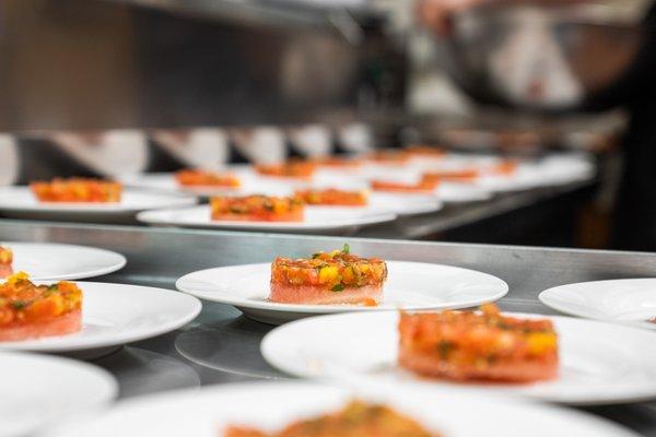 Tomato Tartar with Watermelon and Balsamic Reduction being plated for a multi-course plated dinner.