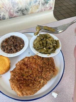 Pork chop dinner with blackeyed peas, green beans and potatoes, and a cornbread muffin.