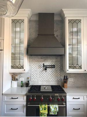 A custom kitchen with top notch appliances and custom cut glass door design.