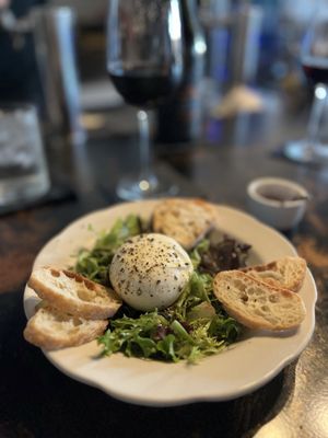 Burrata on a bed of arugula with spicy honey