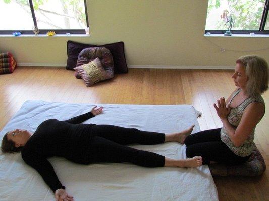 Thai massage is performed on a padded mat with the client wearing comfortable clothing