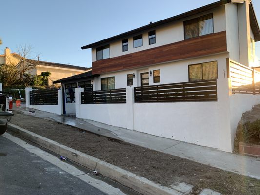 New smooth finish stucco with a hand stained siding and custom metal slack fence.