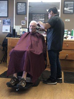 Customer getting a haircut and owner/operator.