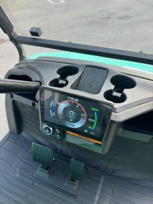 The dashboard of a Sierra LSV golf cart, push to start, 9" touchscreen display with reverse camera, wireless charger, cupholders, speakers.