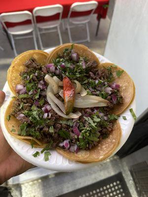 These are asada tacos with onion and cilantro with grilled onions and jalapeño on the side