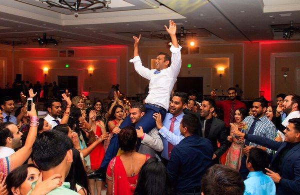 DJ Scorpio rocking the crowd and groom throwing his hands up at Marina Cliffs Hotel in Dana Point, CA