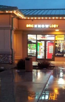 Storefront in the evening, with sign lit.