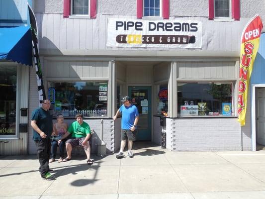 Some customers taking a break on the bench in front of the store.