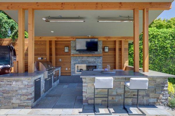 Leschi outdoor kitchen features infrared heaters, milestone counters, gas fireplace and TV