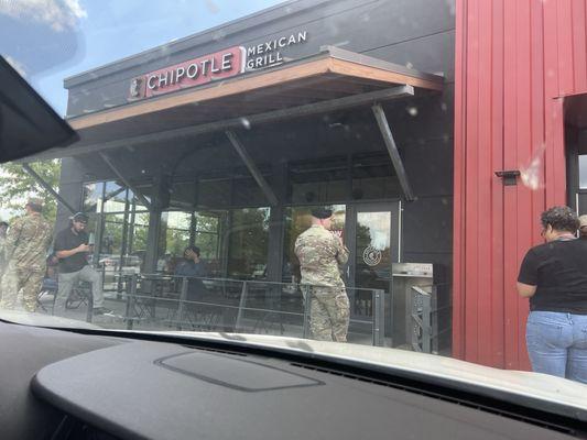 All the people standing outside waiting for their food.