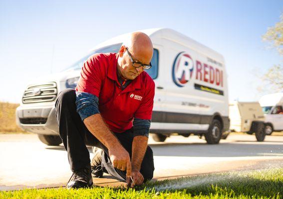 Reddi sprinkler tech adjusting a sprinkler head in Wichita, KS.