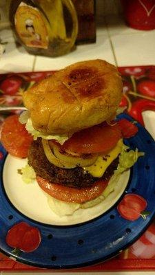 Homemade Burgers with lettuce, tomato, grilled onions, pickles, lettuce & cheese.