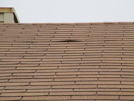 Minor "nail pop" under a roofing shingle.