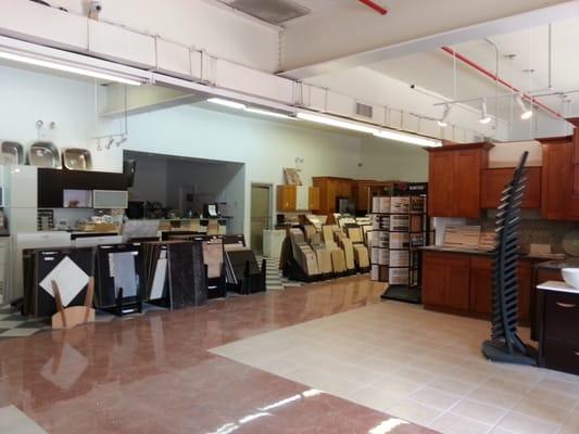 Open floor space with kitchen cabinetry displays aling with stone and tile selections