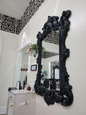 Beautiful accent pieces and mirrors are clean, crisp, and match the lovely wallpaper.