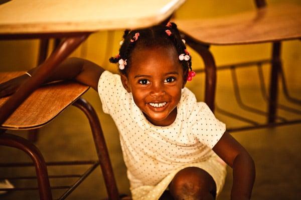 One of our children peeking out from under her desk in La Represa, Dominican Republic.