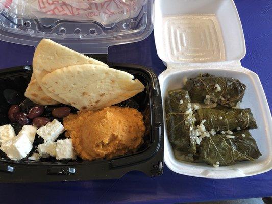 Hummus, pita bread, feta cheese, olives, grape leaves