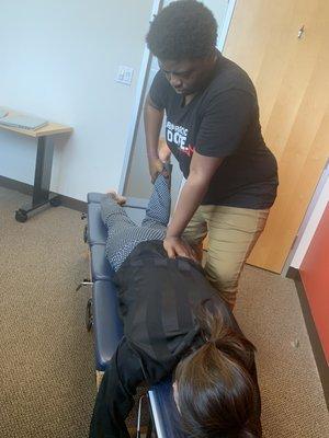 Dr. Arneka giving adjustment in clients workspace.