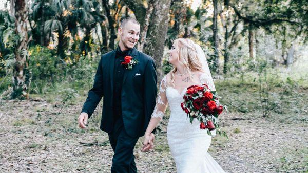 A newlywed couple walk in the woods on their wedding day