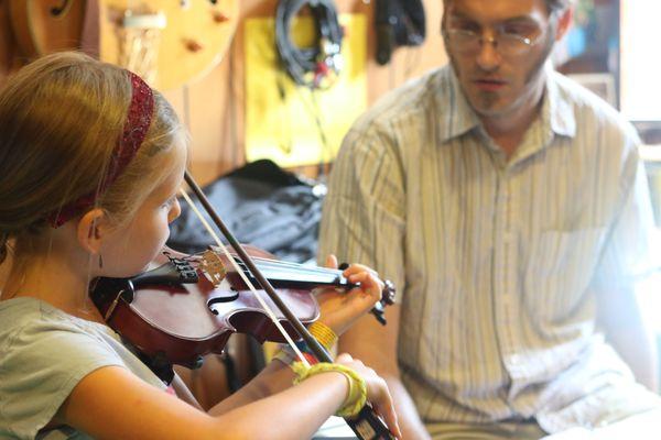 Teaching a girl the violin.