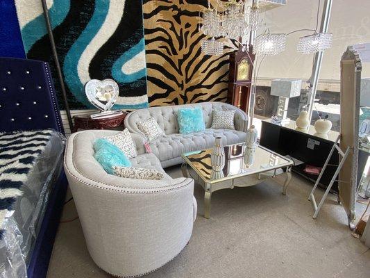 Couch living room area with chandelier, accessories, and mirrored table