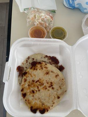 Frijol pupusa and chicharrón pupusa with green and red salsa and cabbage salad