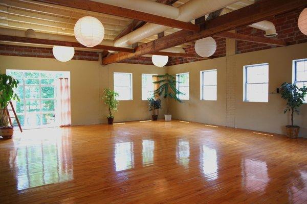 Open and light yoga room with lots of plants