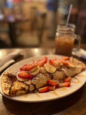 Dulce de Leche Banana Crepe with strawberries and an iced coffee with oat milk.