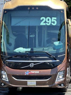 Driver inside the air conditioned bus, waiting for the bus to get cleaned while we wait outside in the súper hot weather.