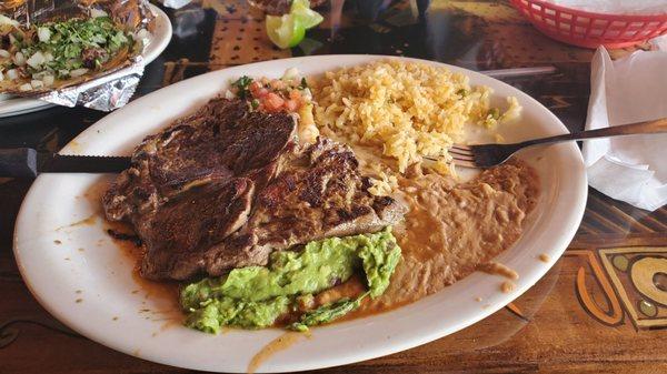 Carne Asada plate with rice and beans with one cheese enchilada.