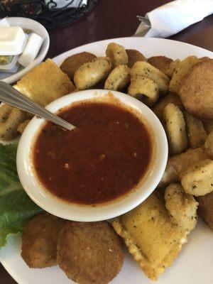 Appetizer plate with fried calamari, zucchini, ravioli, and mozzarella sticks.