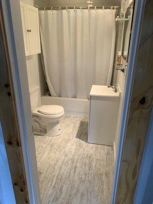 LVT plank flooring with new toilet vanity and toilet