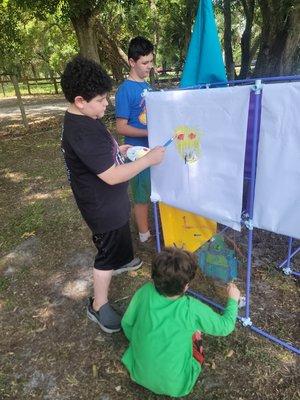 Some of the kids working on an art project under the oaks.