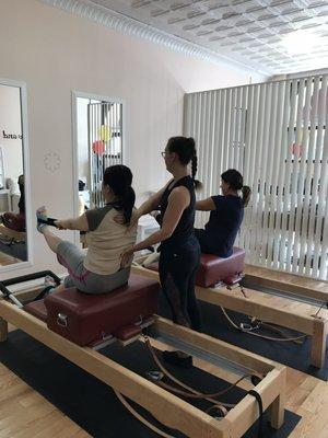 Begginer Class being taught on the reformer. Posture is key to all Pilates exercises!