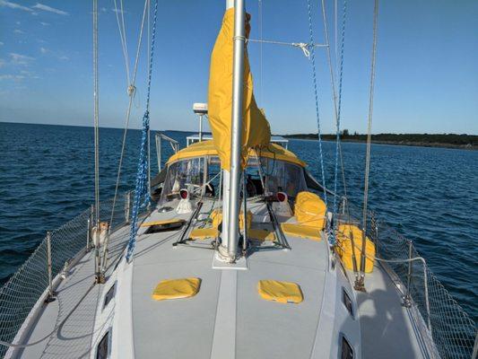 This is looking aft from the bow on a  Catalina 42' with a Sunflower Yellow canvas bimini, sailcover, hatch covers, and jerry can covers.