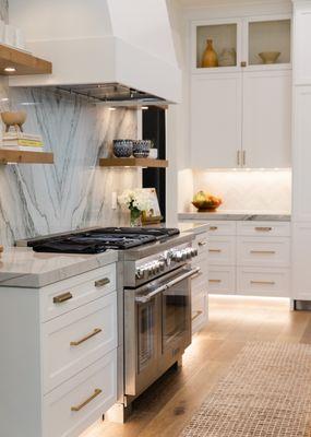 This award winning kitchen features custom wood shelves, toe kick lighting for ambiance and wood flooring throughout.