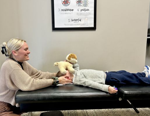 Dr Lisa giving our child adjustments to help him recover from an ear infection.