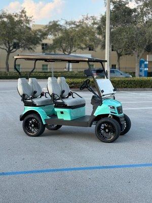 A seafoam green Sierra LSV 4 person forward facing electric golf cart for sale in Miami near the Dolphin Mall.