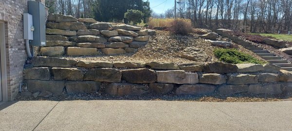 Retaining wall installation with stairs and new landscaping done around with river gravel. Different stone/gravel upon customer request.