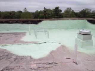 Foam roof installation over concrete roof deck.