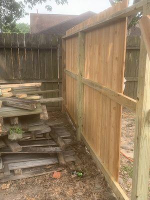 Back of cedar picket fence with treated 2x4 runners and 1x6 treated wrought board