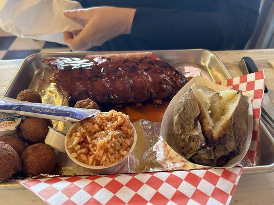 The half a rack of ribs plate with baked potato and coleslaw