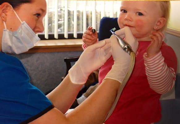 Our youngest patient ever getting her teeth cleaned while giggling "more"