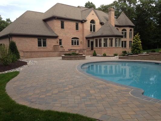 2,000 square foot patio with a raised planter box in the middle with a complete landscape design surrounding the patio area.