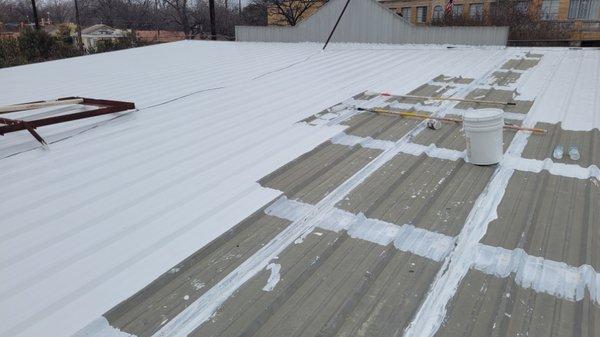 Metal roof being coated