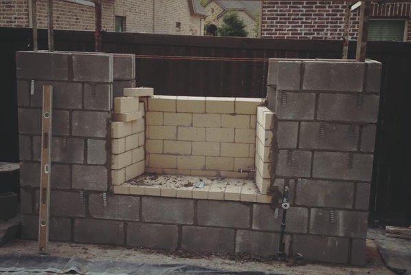 Outdoor fireplace constructed with stone and brick.