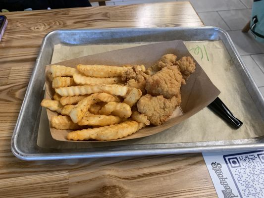 Kids item - popcorn chicken with fries on a tray.