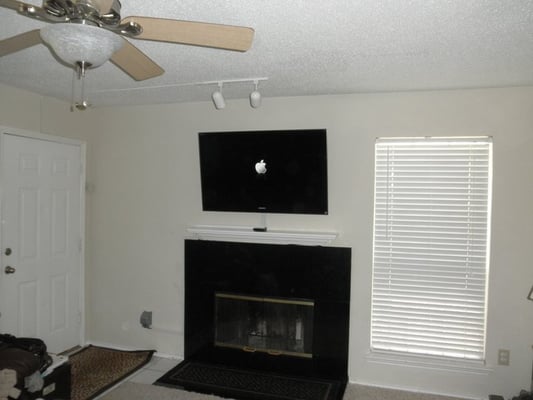 wire mold over fireplace with tv mount and child safety plug over electrical socket in town home McKinney, TX