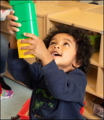 Child in classroom playing with building toy